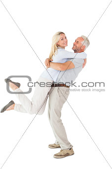 Man picking up his partner while hugging here