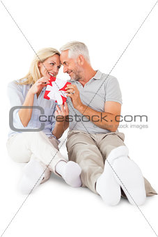 Happy couple sitting and holding present