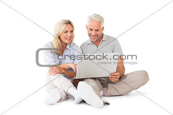 Happy couple sitting and using laptop