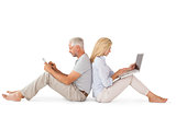 Happy couple sitting using laptop and tablet pc
