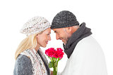Smiling couple in winter fashion posing with roses
