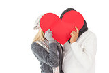 Couple in winter fashion posing with heart shape