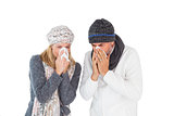 Sick couple in winter fashion sneezing