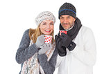 Happy couple in winter fashion holding mugs
