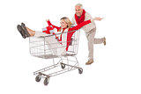 Festive couple messing about in shopping trolley