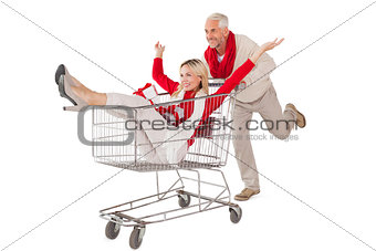 Festive couple messing about in shopping trolley