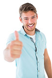 Handsome young man showing thumbs up to camera