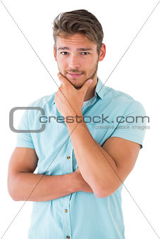 Handsome young man thinking with hand on chin