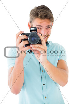 Handsome young man holding digital camera