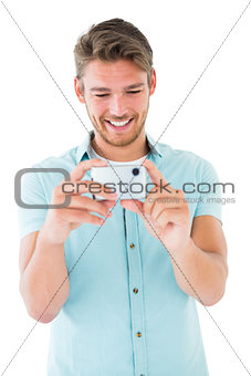 Handsome young man taking photo with smartphone
