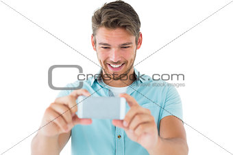 Handsome young man taking photo with smartphone