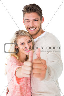 Attractive couple showing thumbs up to camera