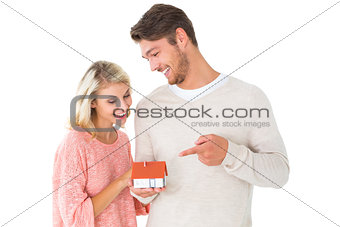 Attractive couple holding miniature house model