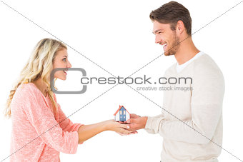Attractive couple holding miniature house model