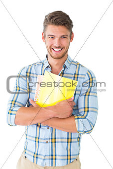 Handsome student holding notepad smiling at camera