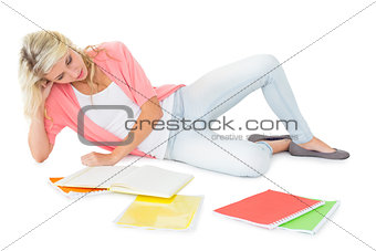 Pretty young blonde lying and studying