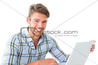 Handsome young man sitting using laptop