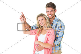 Attractive young couple embracing and pointing