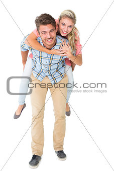 Handsome man giving piggy back to his girlfriend