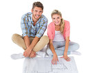 Attractive young couple sitting looking at blueprint