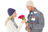 Attractive man in winter fashion offering roses to girlfriend