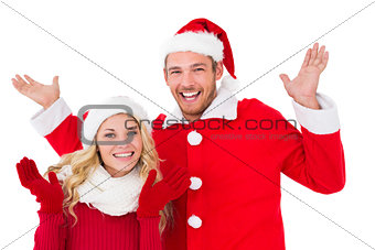 Festive couple smiling with arms raised