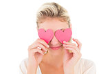 Attractive young blonde holding hearts over eyes