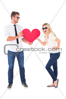 Cool young couple holding red heart