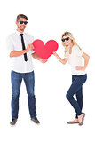 Cool young couple holding red heart