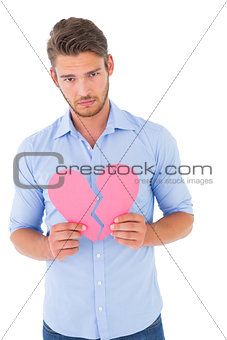 Sad man holding a broken heart