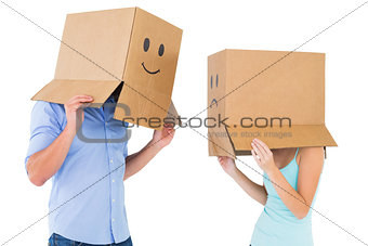 Couple wearing emoticon face boxes on their heads