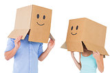 Couple wearing emoticon face boxes on their heads