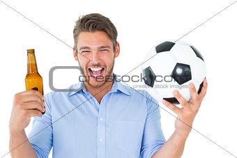 Handsome young man holding ball and beer