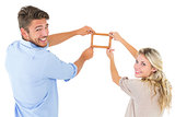 Attractive young couple hanging a frame