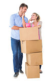 Attractive young couple leaning on boxes with piggy bank