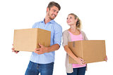 Attractive young couple carrying moving boxes