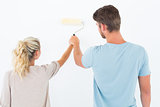 Young couple painting with roller