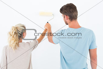 Young couple painting with roller