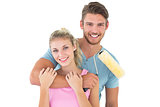 Young couple hugging and holding paint roller