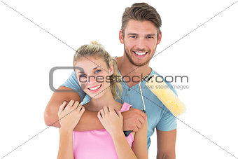 Young couple hugging and holding paint roller