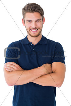 Handsome young man smiling with arms crossed