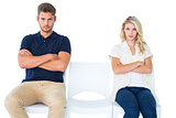 Young couple sitting in chairs not talking during argument