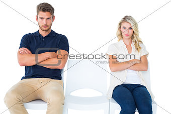 Young couple sitting in chairs not talking during argument