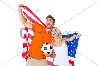 Excited football fan couple holding usa flag