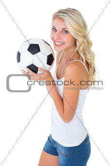 Pretty blonde football fan holding ball