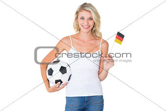 Pretty german football fan waving flag holding ball