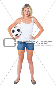 Pretty blonde football fan holding ball