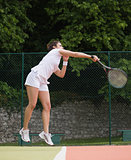 Pretty tennis player jumping and hitting