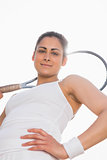 Pretty tennis player holding racket smiling at camera