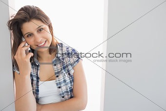 Pretty brunette sitting beside her window talking on phone